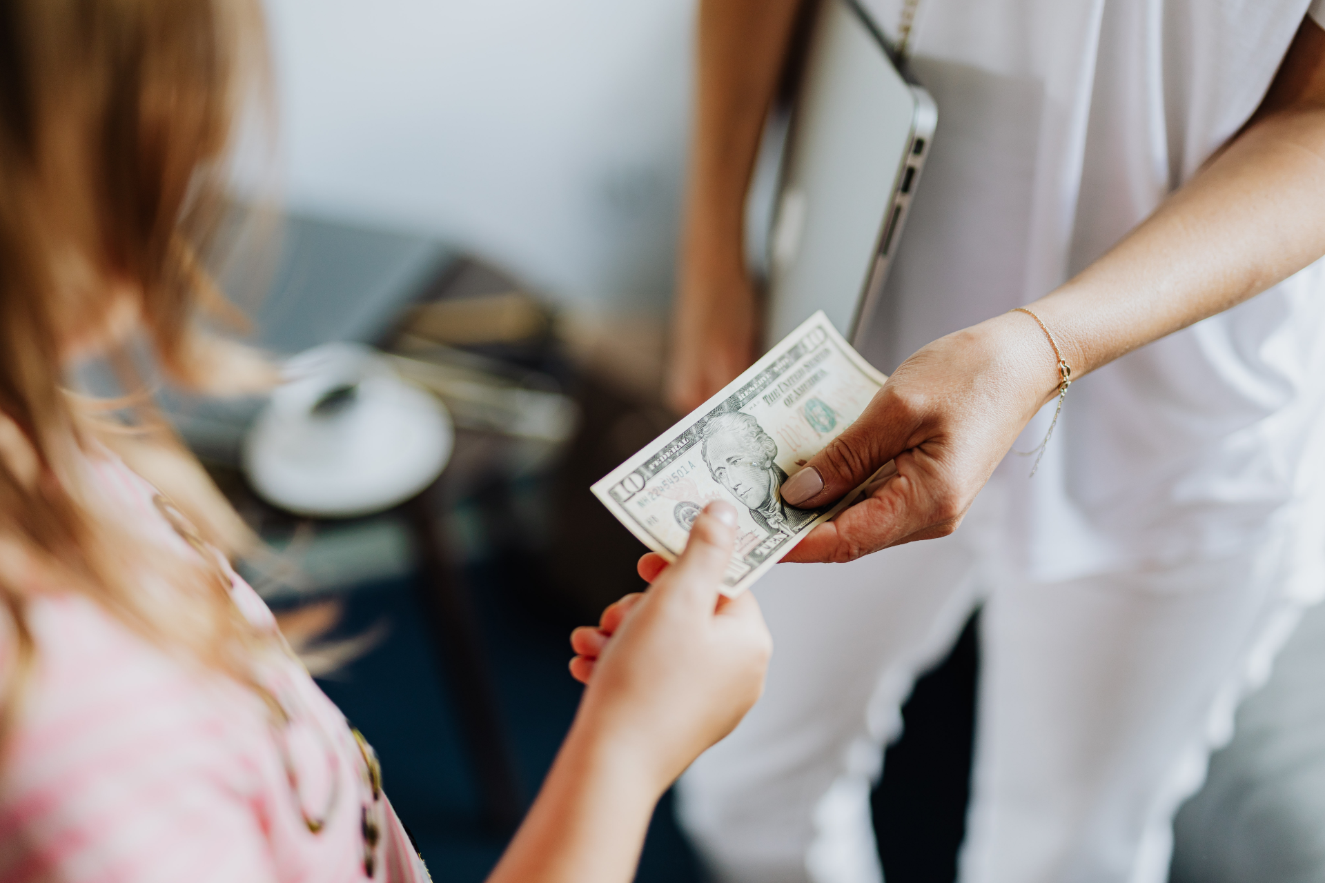 Semi-truck and trailer crashed off road. People stand near wreckage, green field, blue sky.