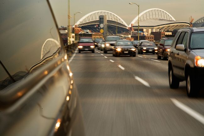 Cars on a highway towards a bridge at dusk.