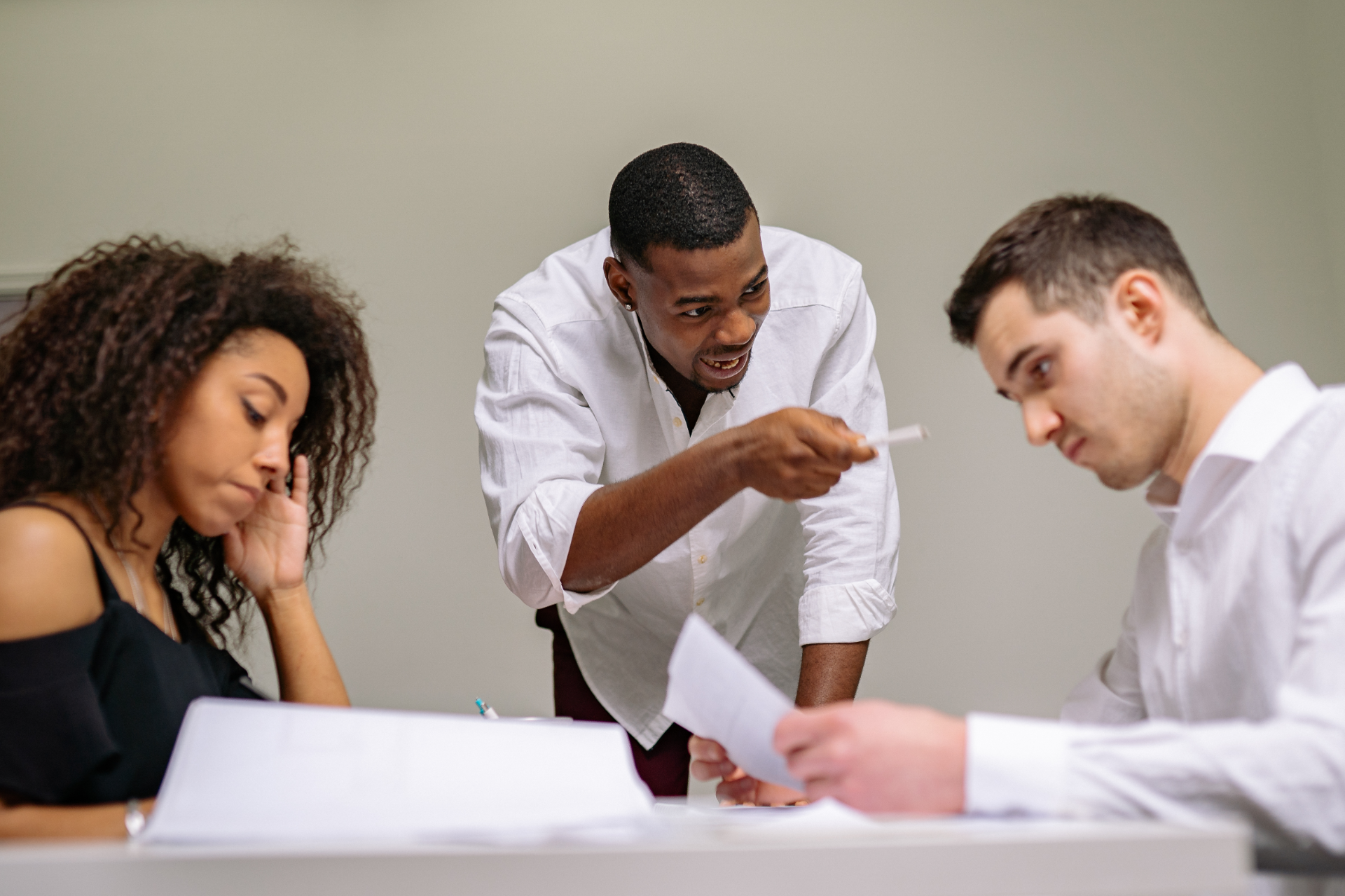 Semi-truck crashed on side of highway, being towed. White cab, trailer, orange cones, tow truck.