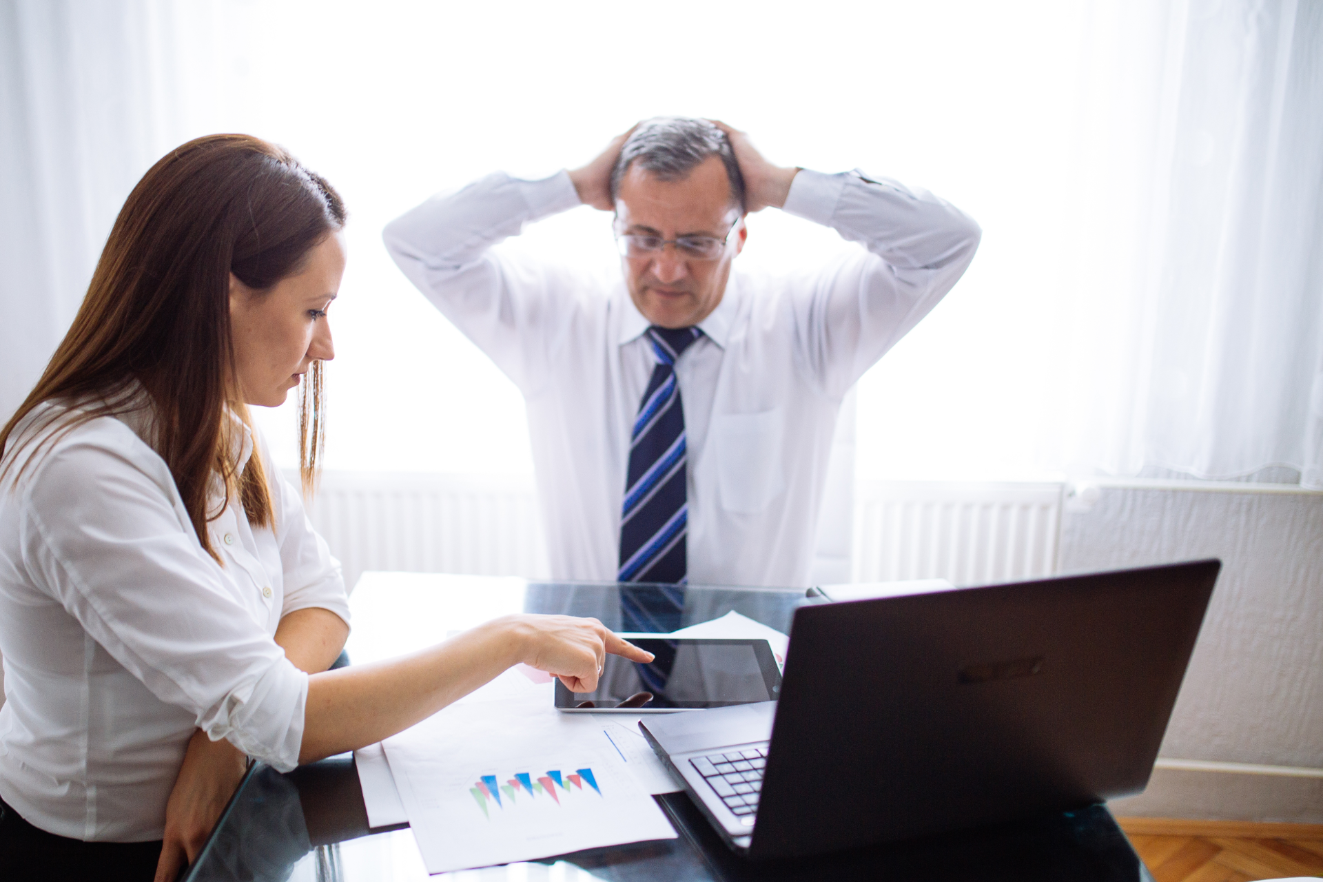 Semi-truck crashed on side of highway, being towed. White cab, trailer, orange cones, tow truck.