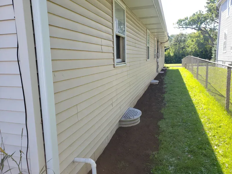 A house with a drain on the side of it
