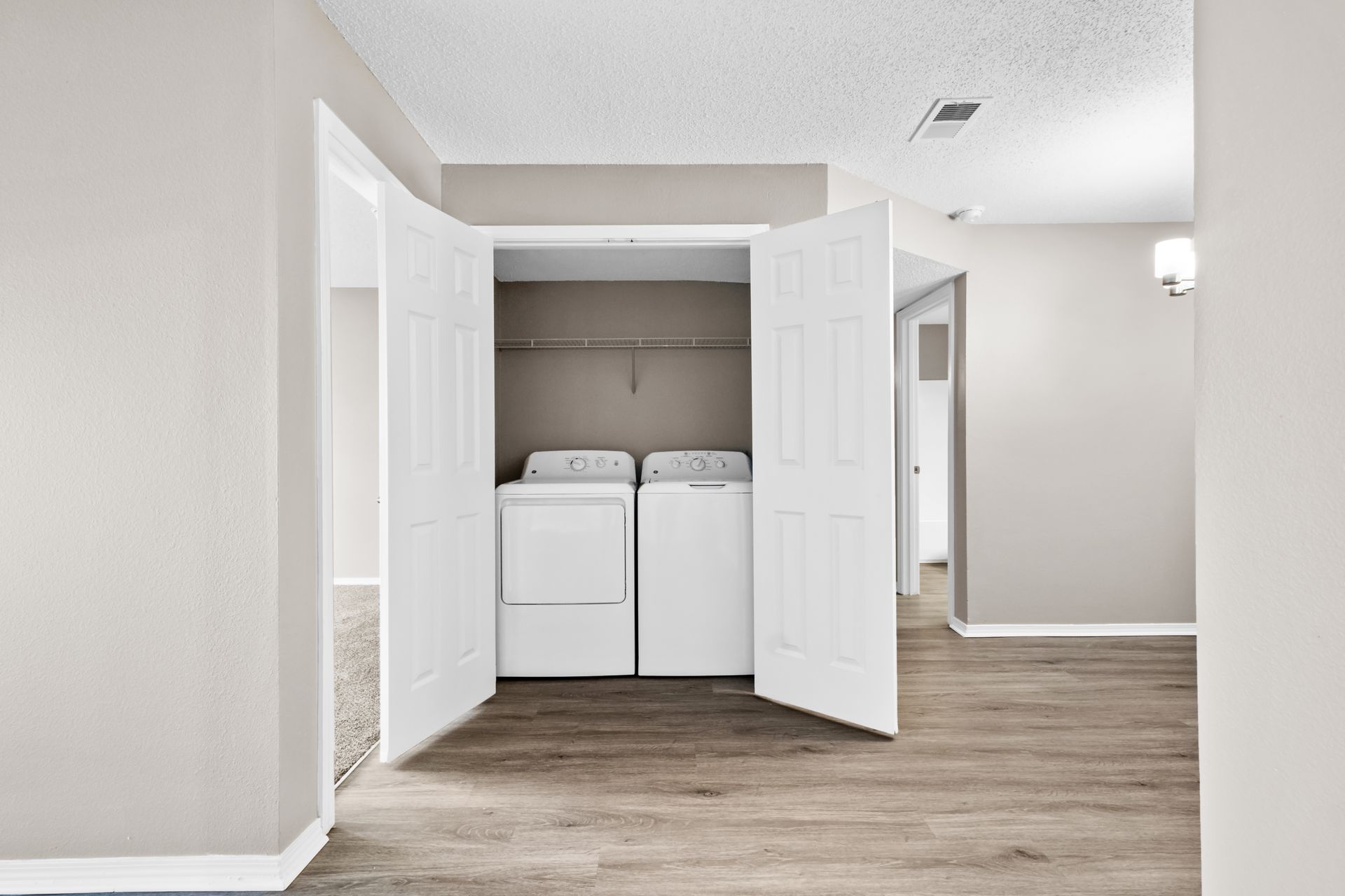 A laundry room with a washer and dryer in a closet at 73TwentyFive apartment in North Little Rock, AR.