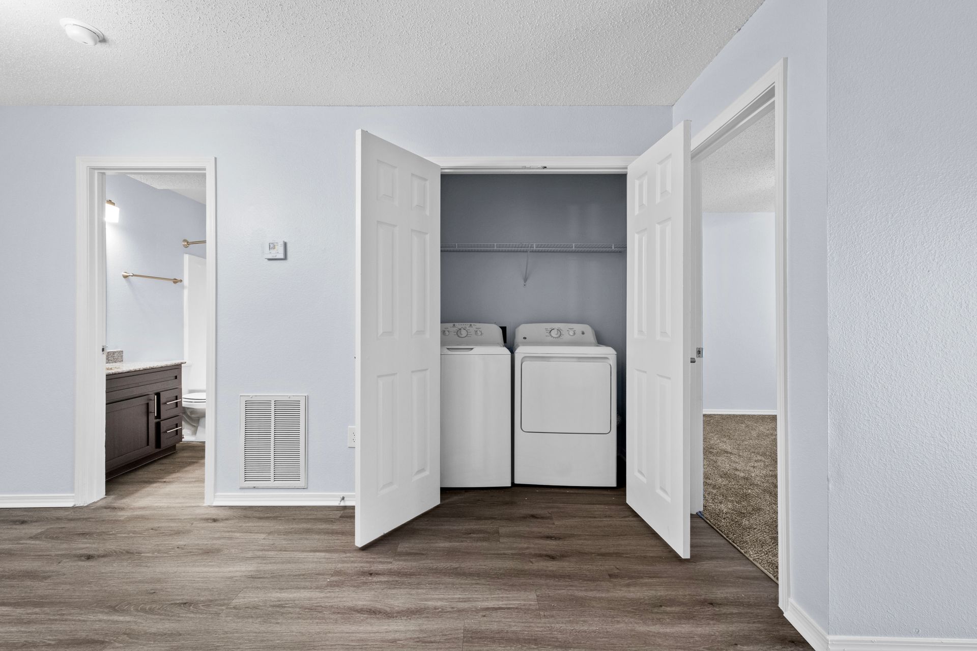 An empty room with a washer and dryer in a closet at 73TwentyFive apartment in North Little Rock, AR.