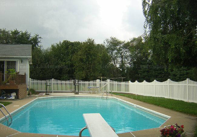 A large swimming pool with a diving board in the backyard.