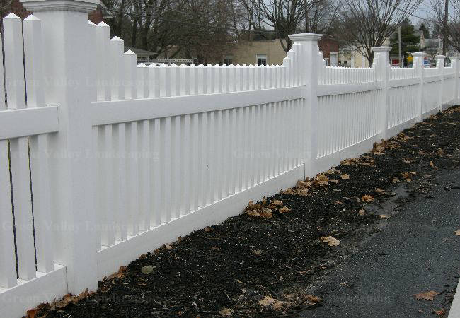 A white picket fence along the side of a road