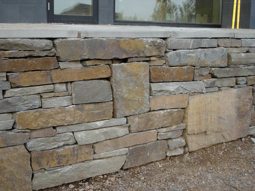 A stone wall is being built in front of a building.