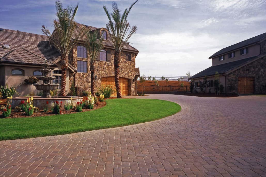 A large house with a brick driveway in front of it