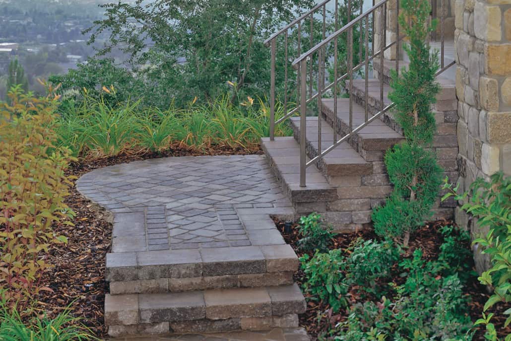 A stone walkway with stairs leading up to a house.