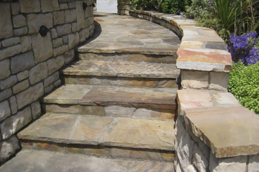A set of stone stairs leading up to a stone wall.