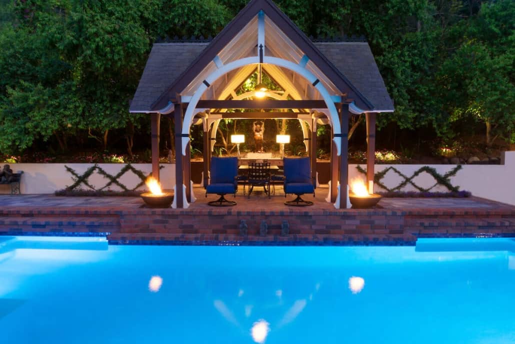 A large swimming pool with a gazebo in the background
