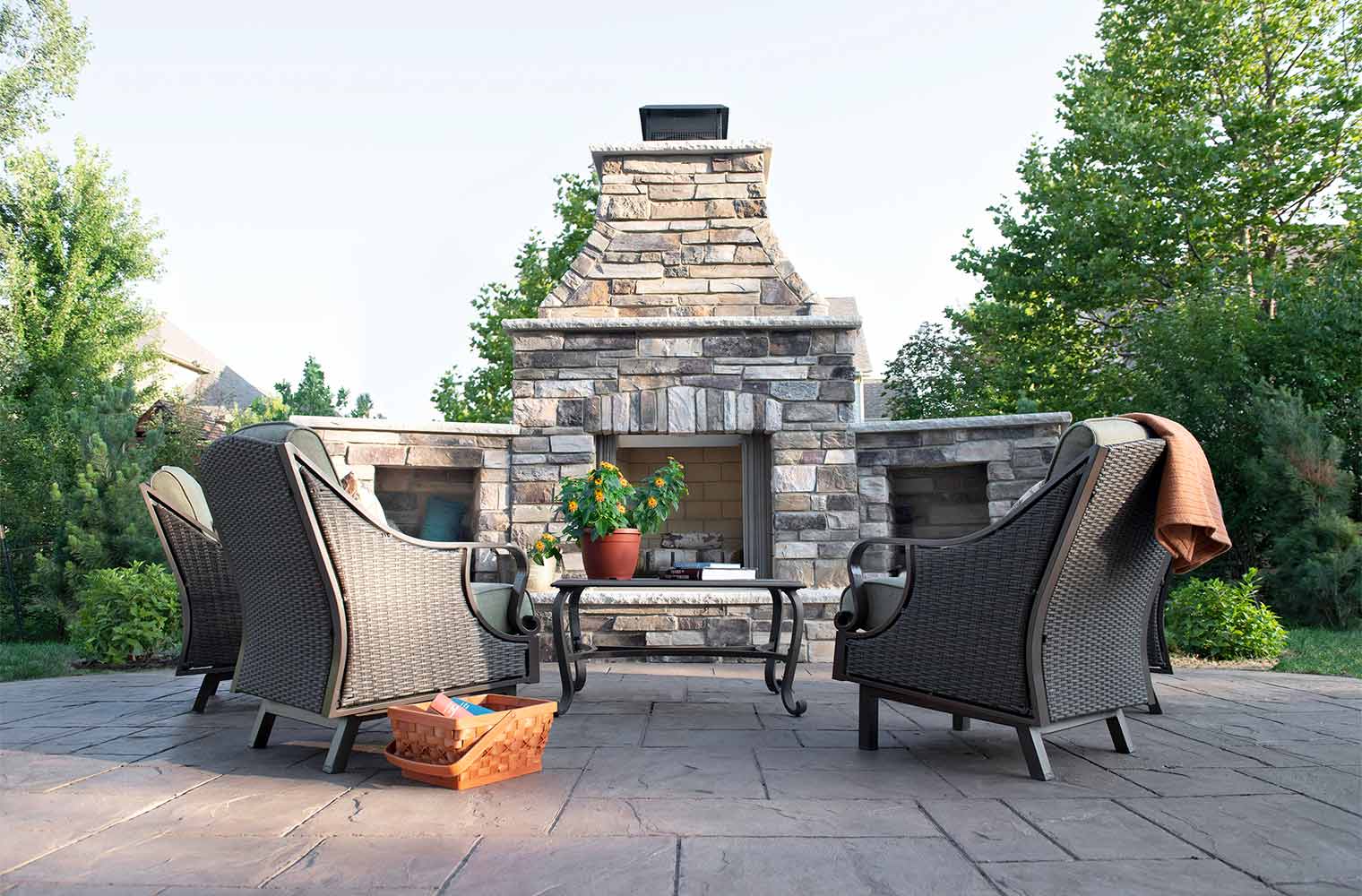 A patio with chairs and a fireplace in the background