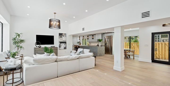 A living room with a white couch and a flat screen tv.