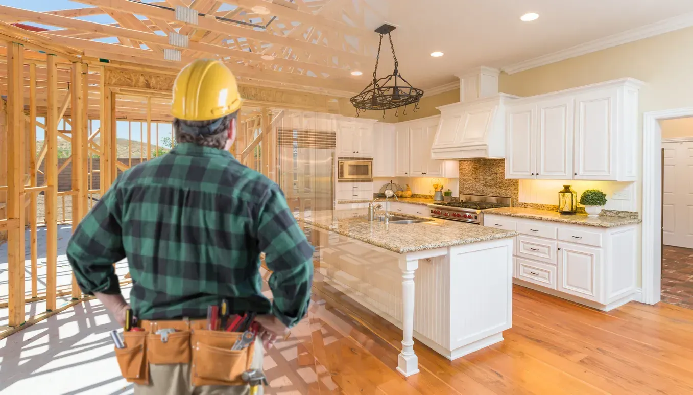 A construction worker is standing in front of a kitchen under construction.