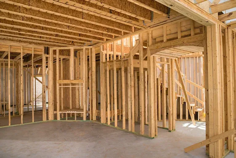 The inside of a house under construction with wooden beams.