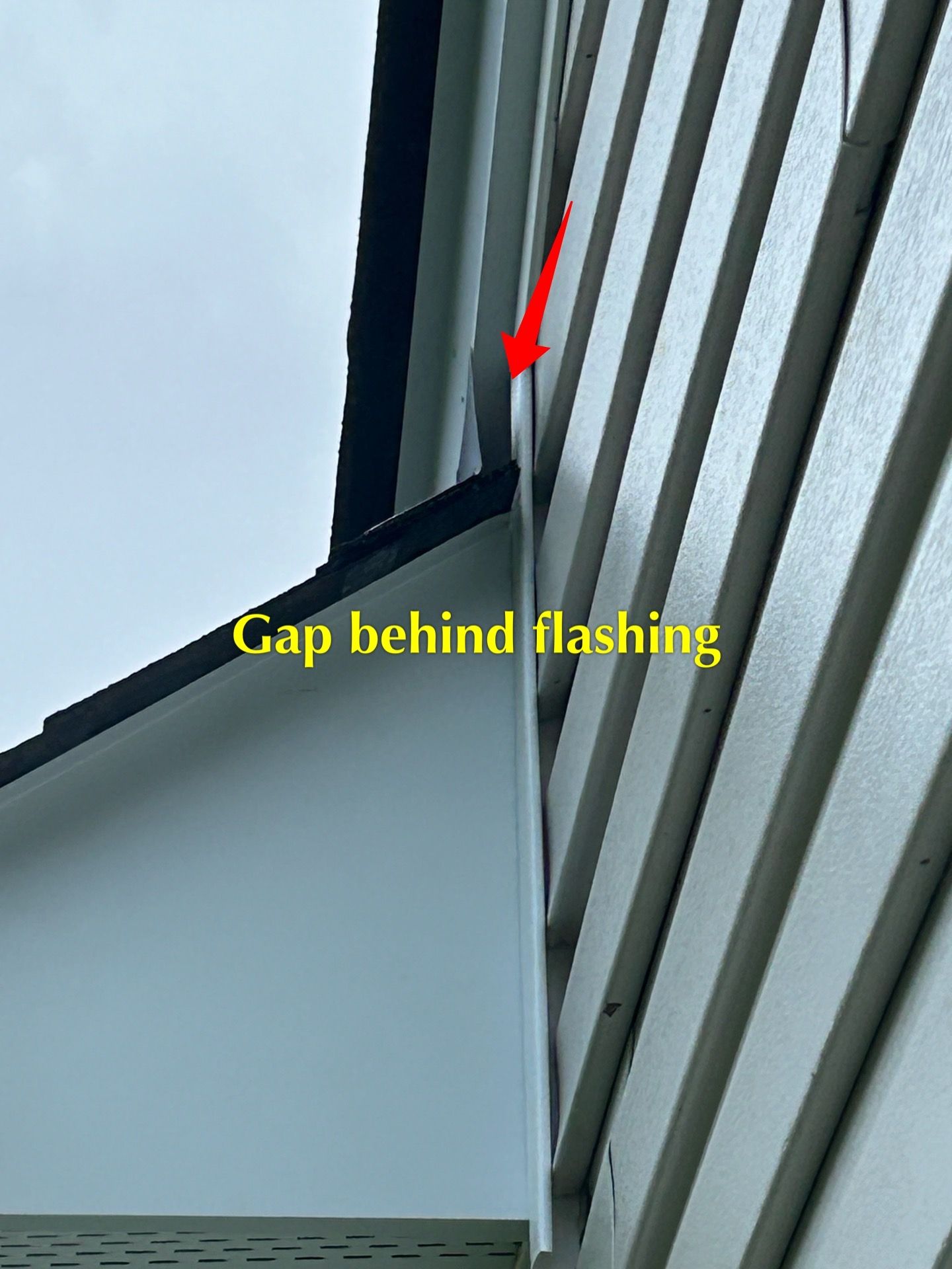 There is a gap behind the flashing on the side of a building.