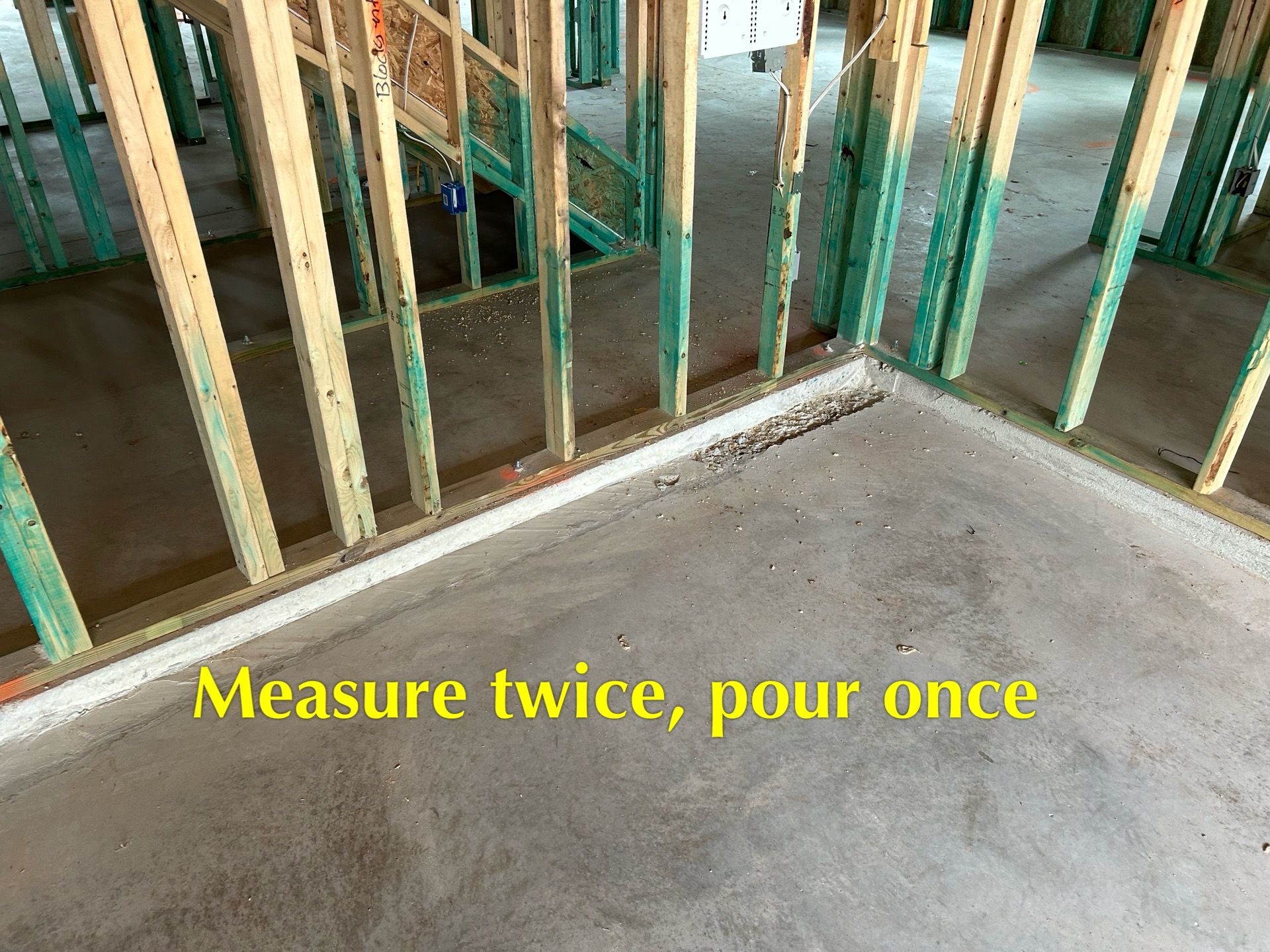 A picture of a building under construction with the words measure twice pour once