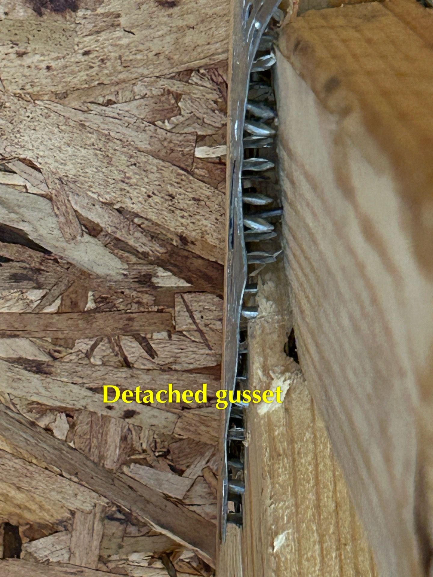 A close up of a piece of wood with a detached gusset.