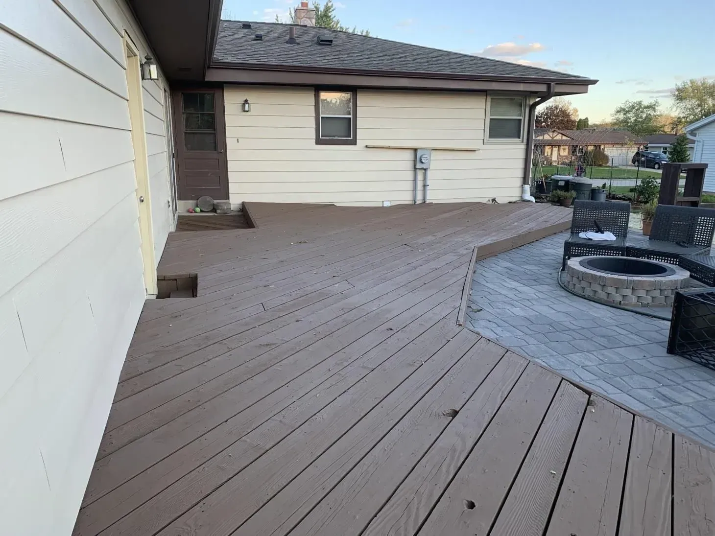 Wooden deck with a fire pit and house exterior.