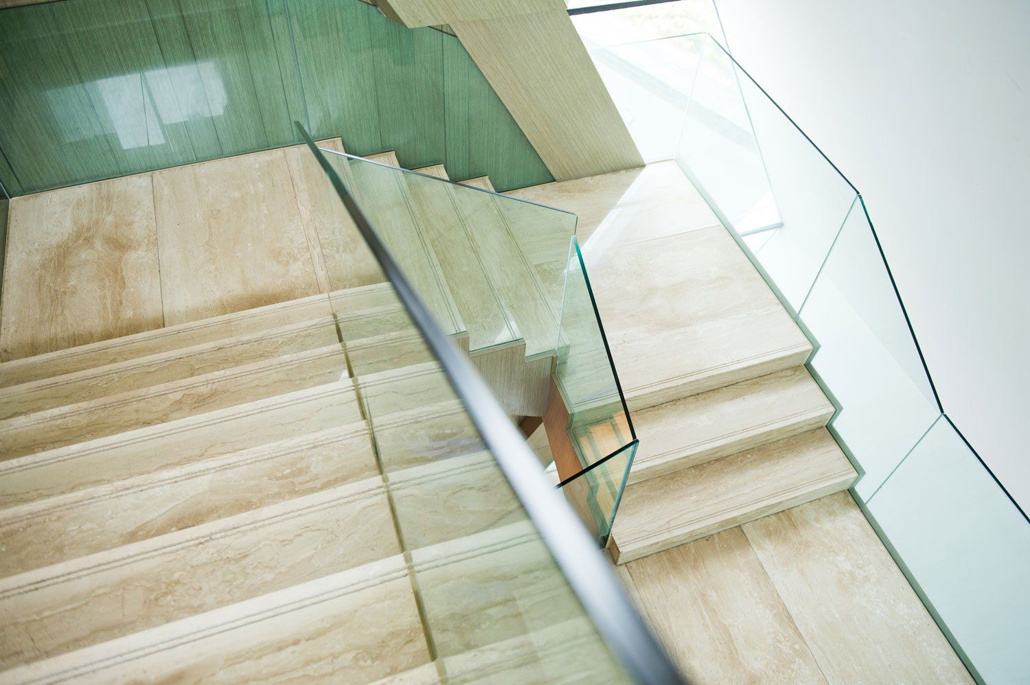 A close up of a staircase with a glass railing