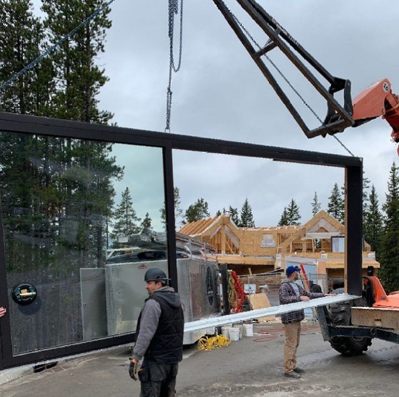 A crane is lifting a large piece of glass