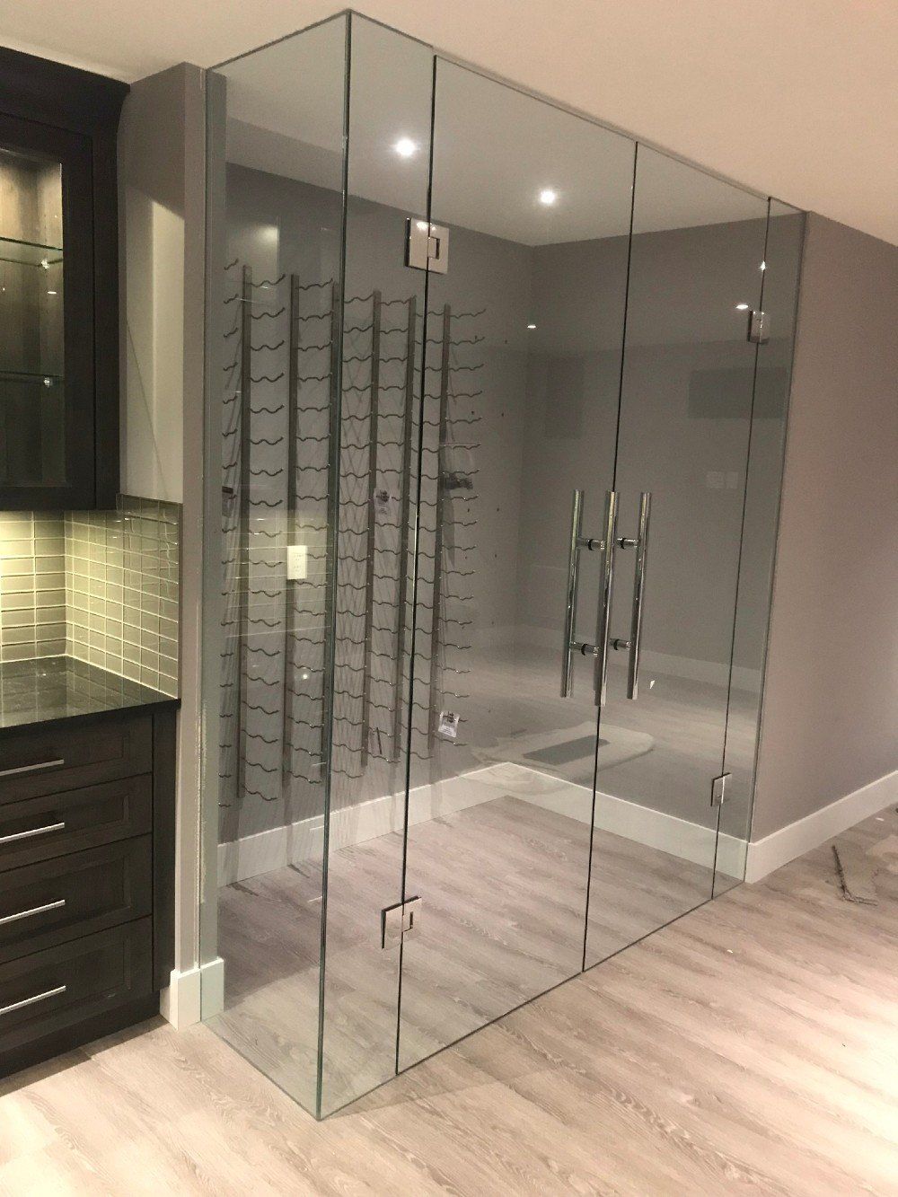 A room with a glass wall and a wine rack in it.