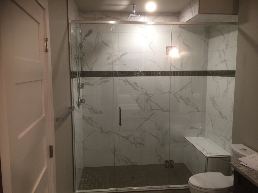 A bathroom with a walk in shower and a toilet.