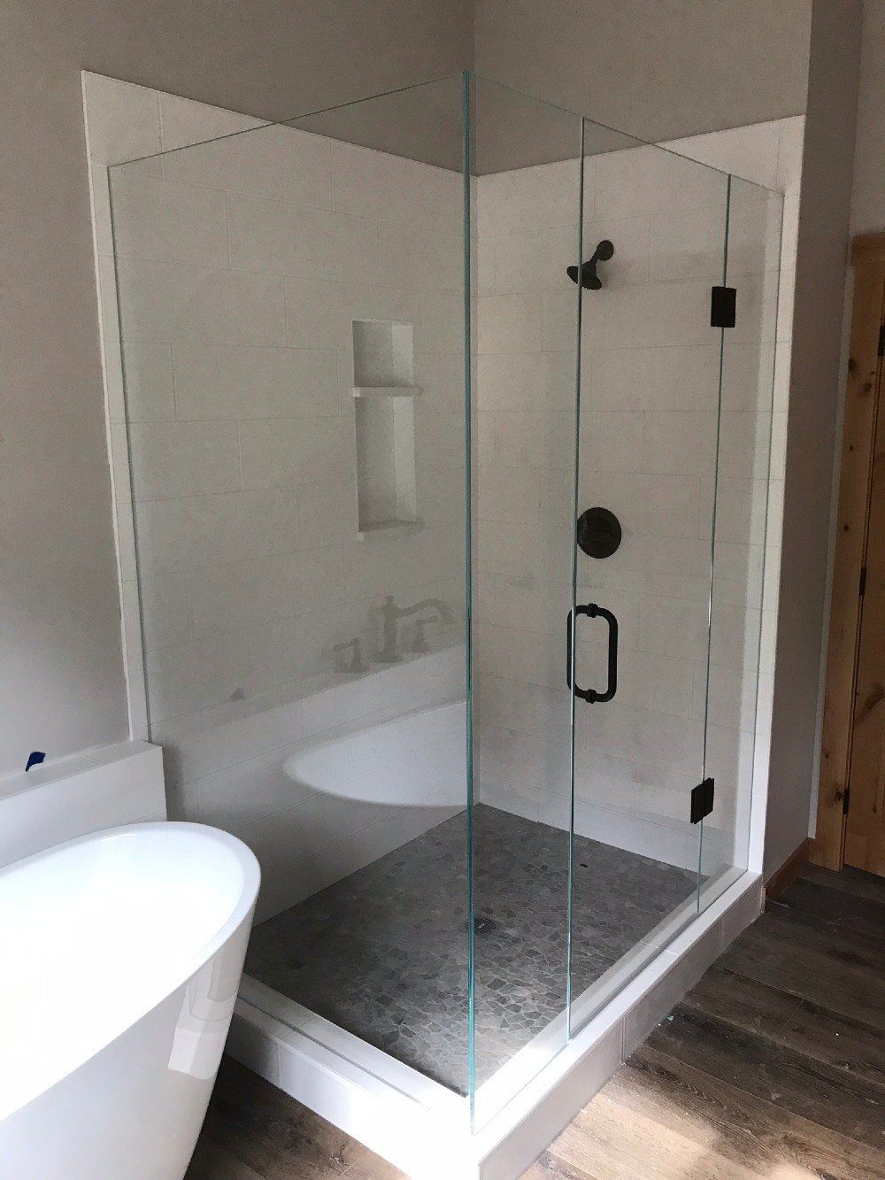 A bathroom with a walk in shower and a bathtub.