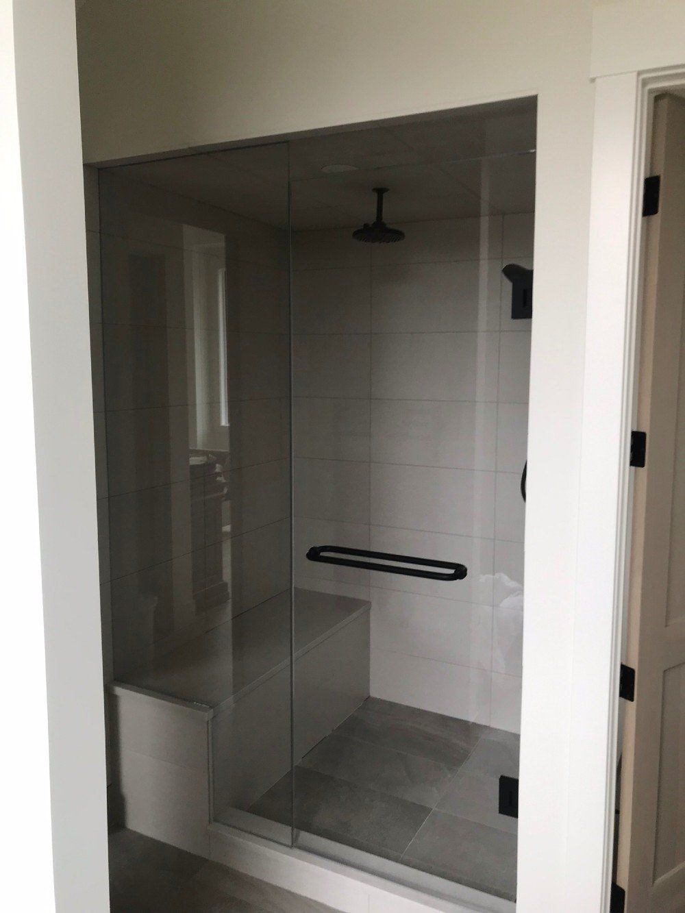 A bathroom with a walk in shower with a glass door.