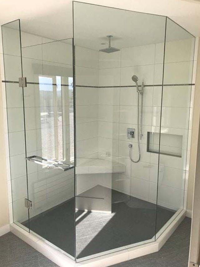 A bathroom with a glass shower stall and a shower head.