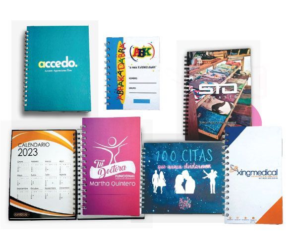 Un montón de cuadernos están colocados uno encima del otro sobre una mesa.