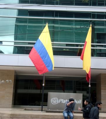 Un hombre se sienta en las escaleras de un edificio con un cartel que dice 