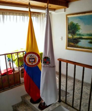 Dos banderas en una habitación con una pintura en la pared.