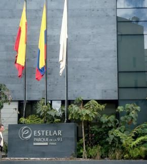Tres banderas ondean frente a un edificio estelar