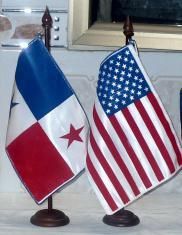 Dos pequeñas banderas están una al lado de la otra sobre una mesa.