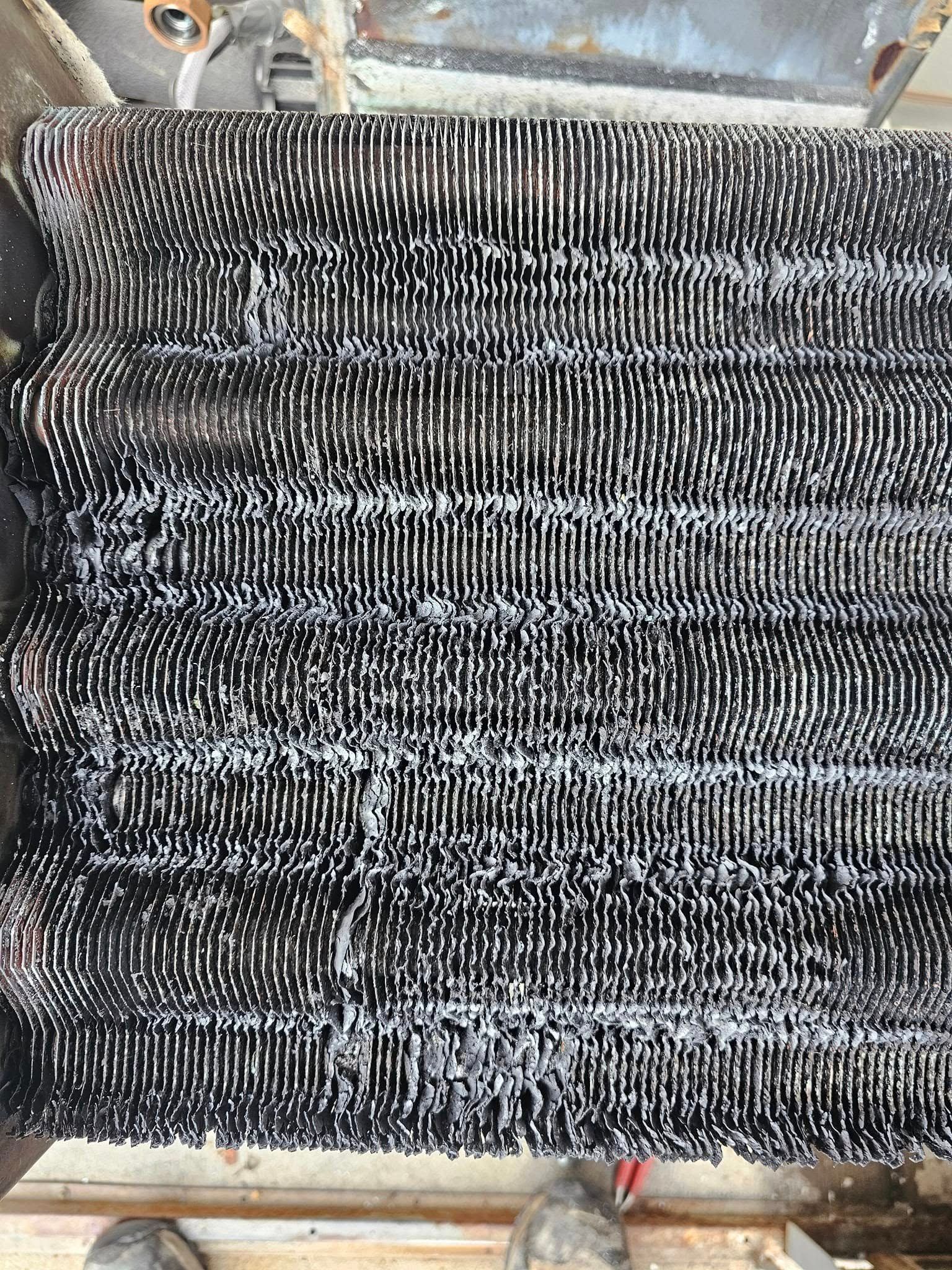 Black and white metal mesh with white frost or buildup on it.