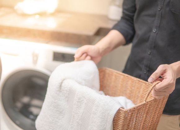 Laundry Facility — Man Holding A Laundry Basket in Holyoke, MA