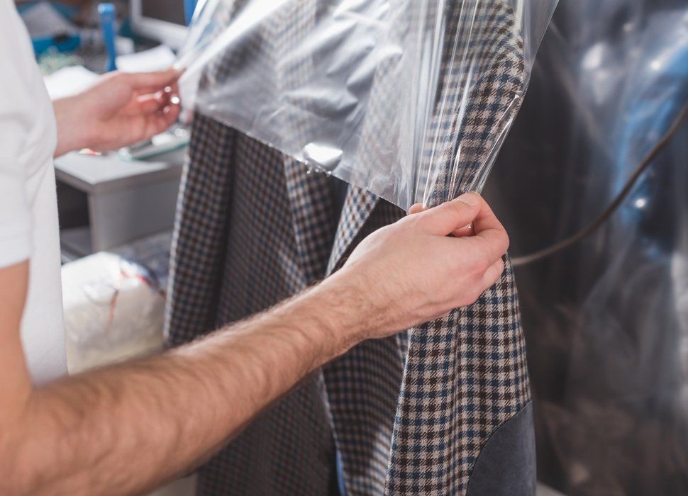 Dry Cleaners — Worker Packing A Jacket In Plastic Bag in Holyoke, MA Dry Cleaners — Worker Packing A Jacket In Plastic Bag in Holyoke, MA