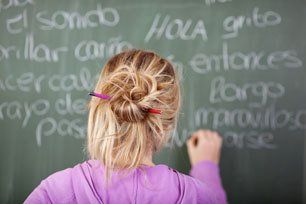 Female student during Spanish Class in front of a blackboard