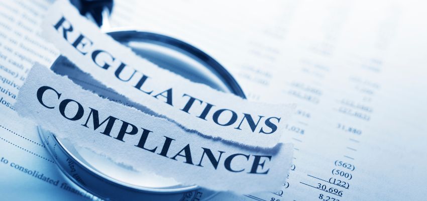 A strip of paper with the words regulation and compliance.