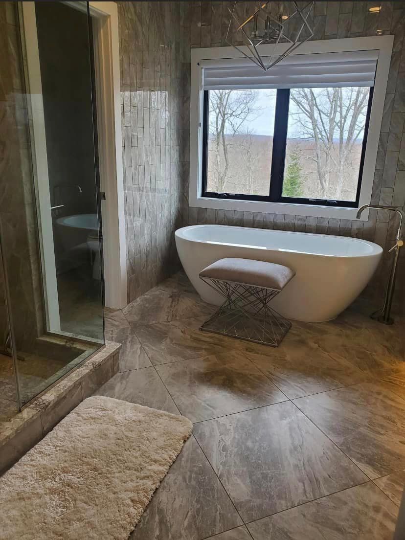 A bathroom with a tub , shower , and window.