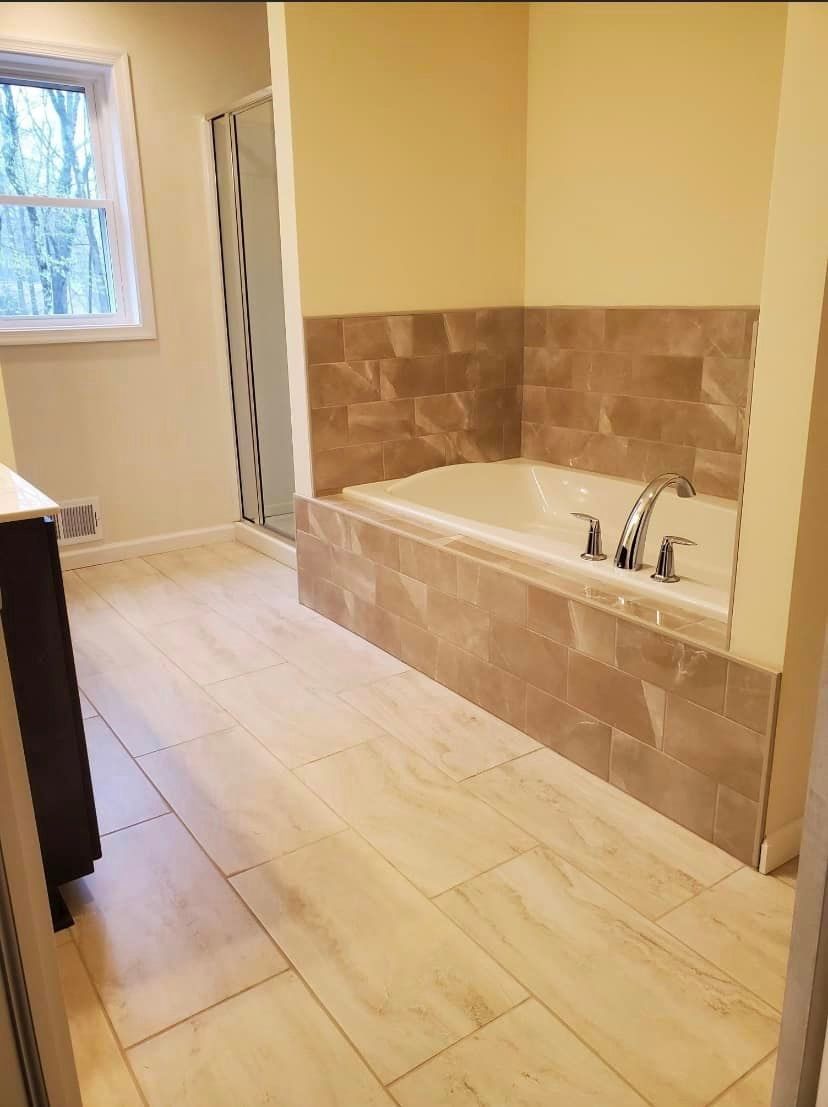 A bathroom with a bathtub and a window.