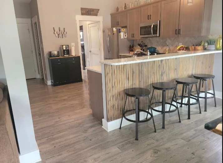 A kitchen with a bar and stools in it