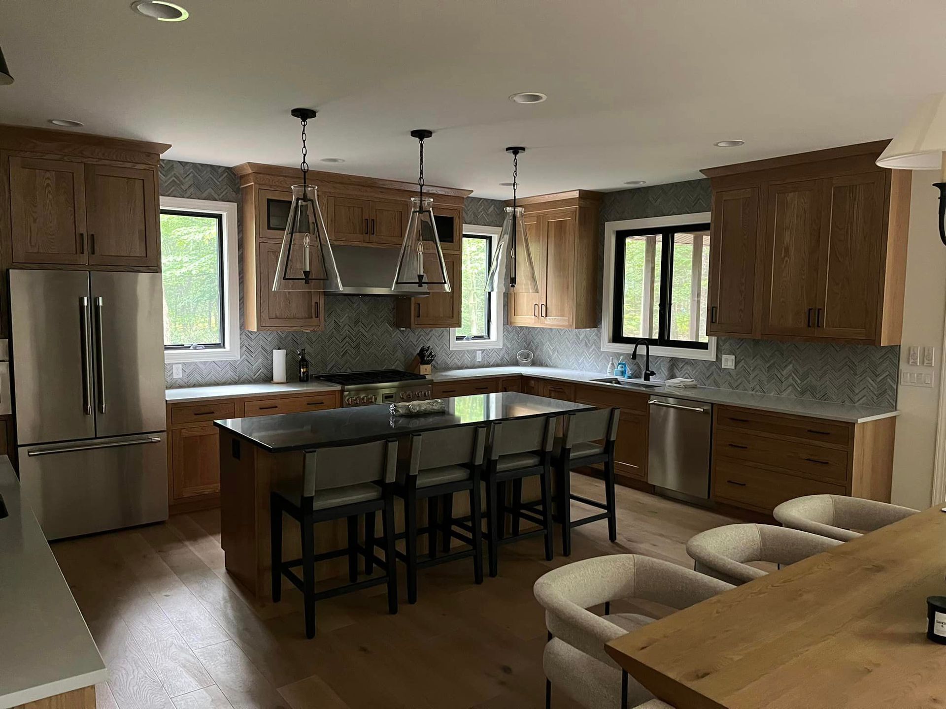 A kitchen with wooden cabinets , stainless steel appliances and a large island.