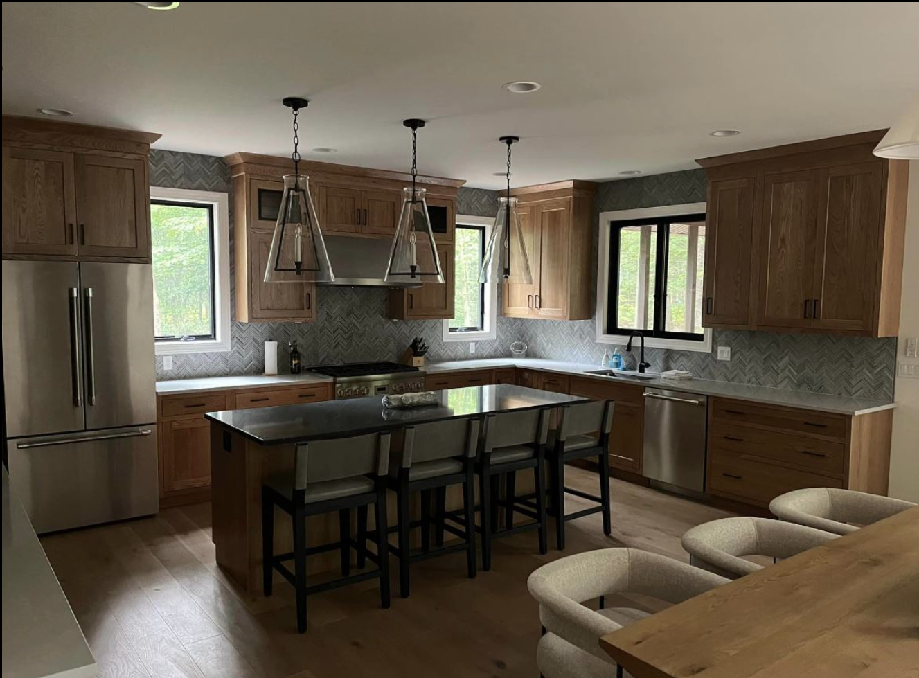 A kitchen with wooden cabinets , stainless steel appliances , and a large island.