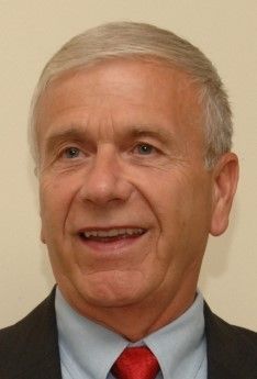 A man in a suit and tie is smiling for the camera.