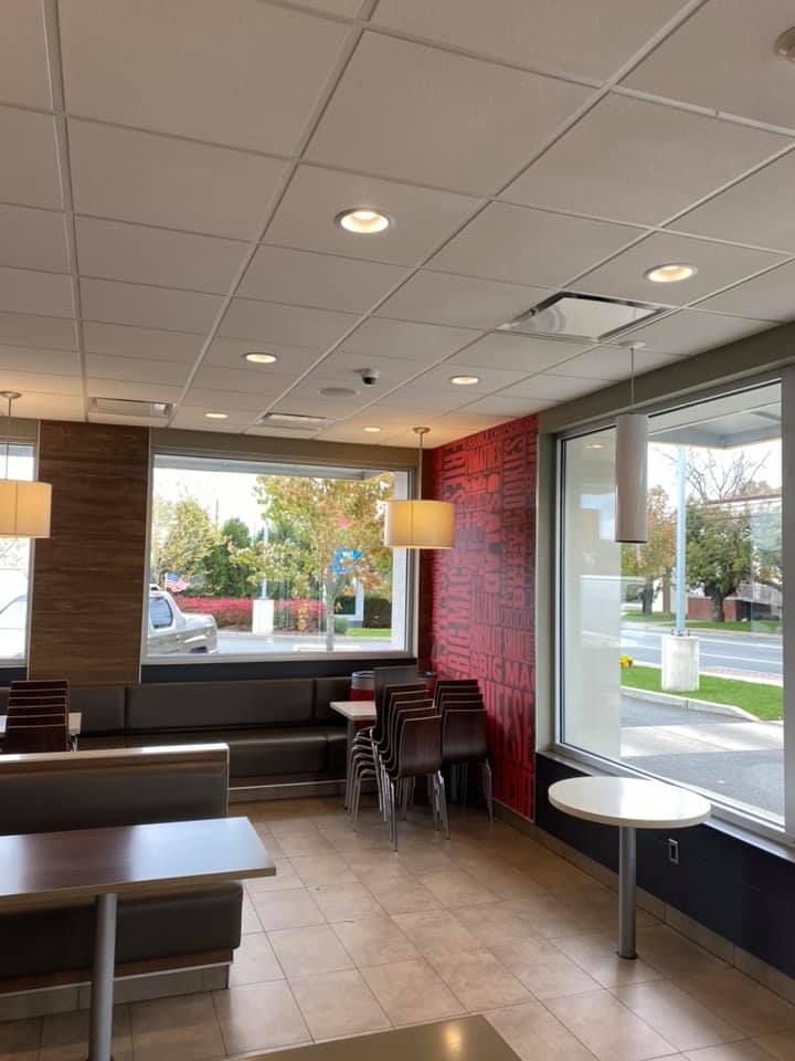 A restaurant with tables and chairs and a large window.