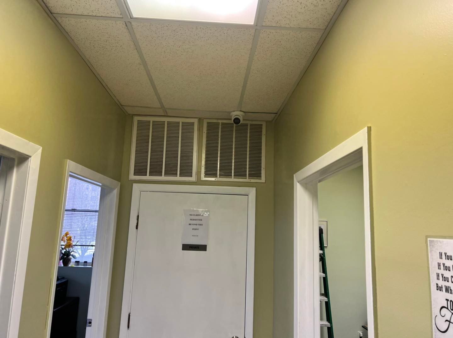 A hallway with a white door and a ceiling fan