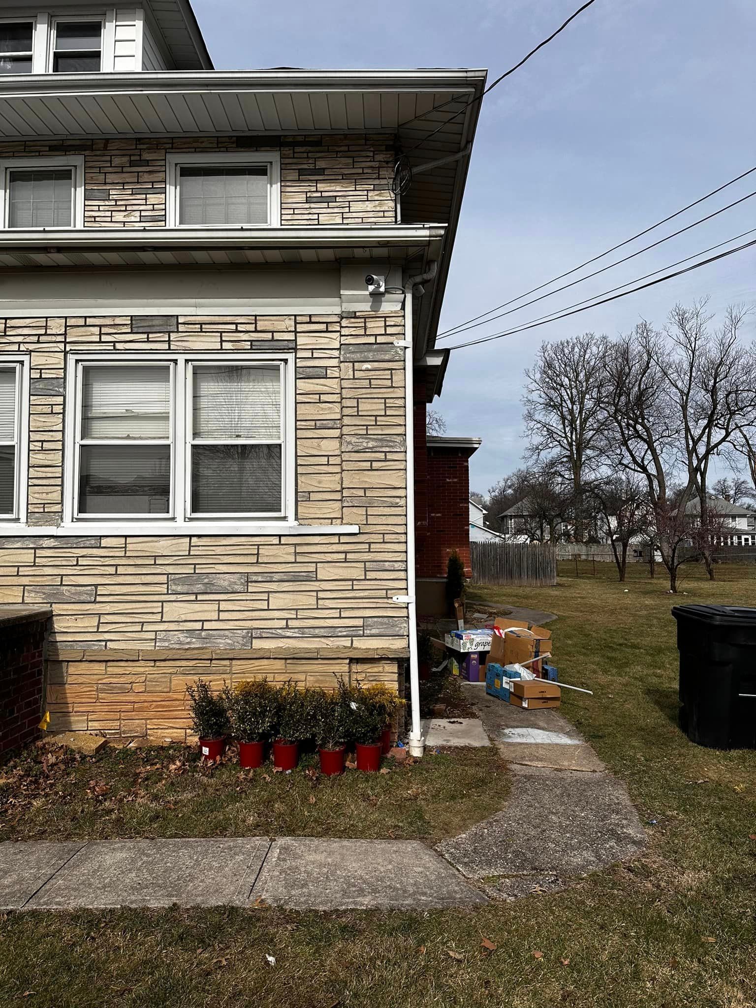 A brick house with a lot of potted plants in front of it.