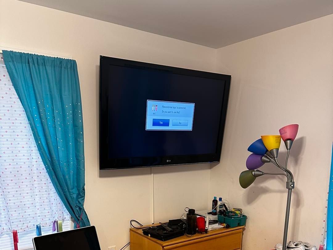 A bedroom with a flat screen tv on the wall