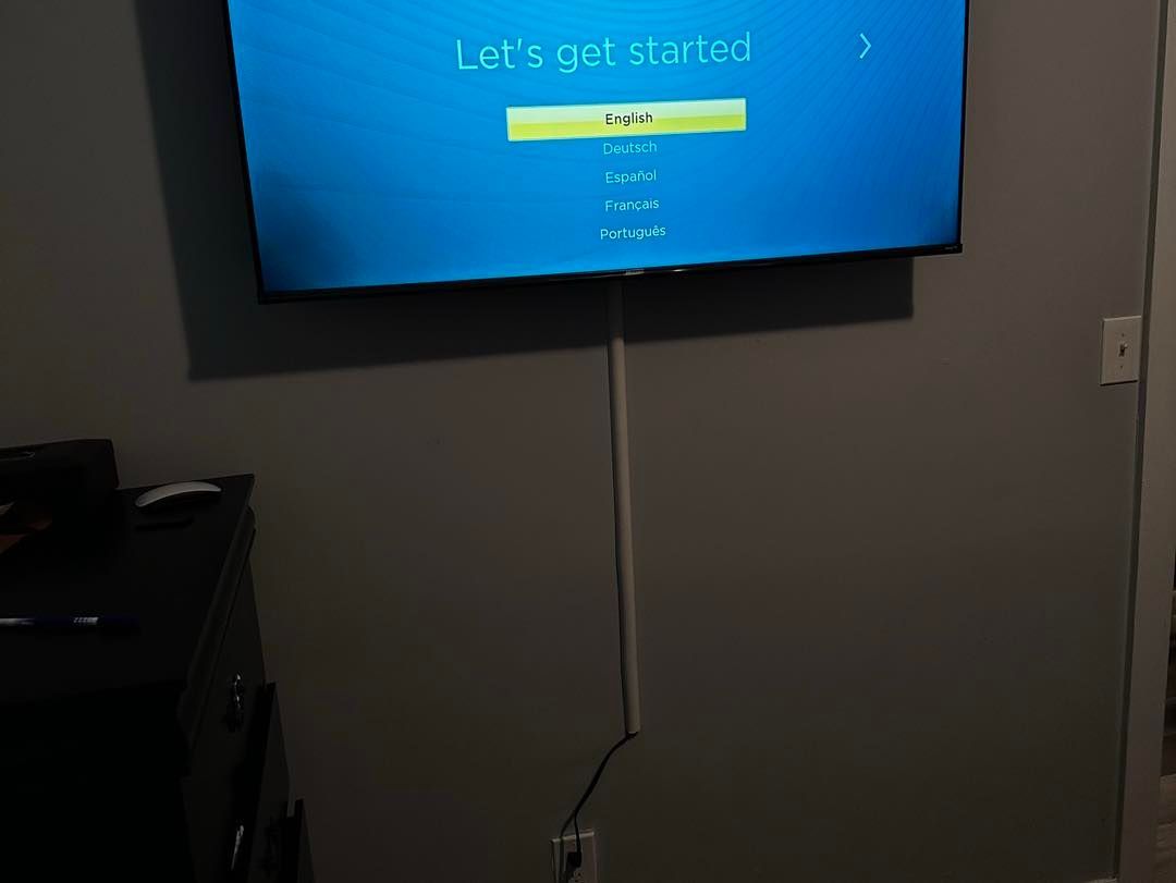 A flat screen tv is hanging on a wall in a living room.